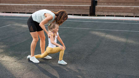 Caucasian woman goes in for sports with her daughter outdoors. A schoolgirl and her mother are...