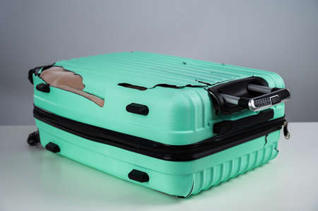 Broken plastic mint suitcase on a white background.