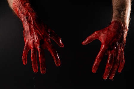 Male bloody hands on a black background.の写真素材