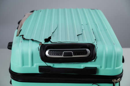 Broken plastic mint suitcase on a white background.の写真素材
