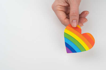 Female hands with rainbow paper heart isolated on white background. Copy space.の写真素材
