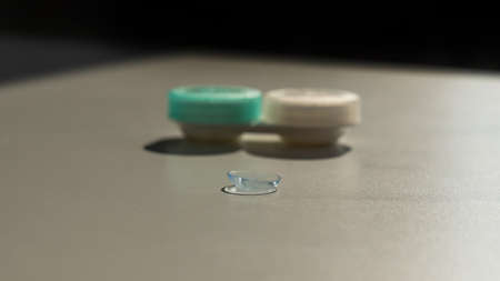 Contact lenses and a storage container on a white table.