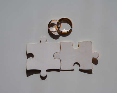 Wedding rings and puzzle pieces. Husband and wife complement each other perfectly.の写真素材