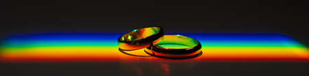 Rainbow beam on wedding rings. lgbt flag.