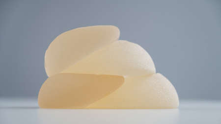 A pile of breast implants on a white background.