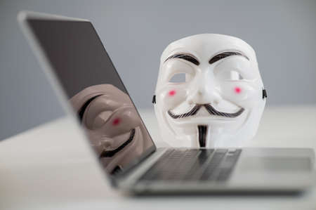 Novosibirsk, Russia May 30, 2022: An anonymous mask on a laptop on a white background.