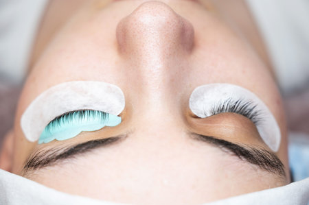 Close-up portrait of a woman in a beauty salon on eyelash lamination procedure.の写真素材