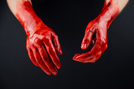 Womens hands in blood on a black background.の写真素材