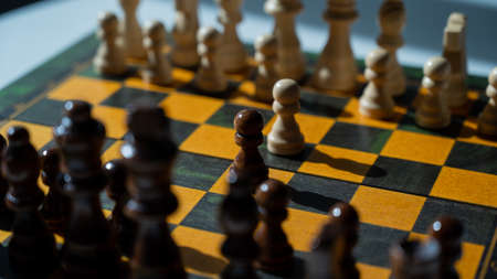 Chessboard with pieces on a white table.の写真素材