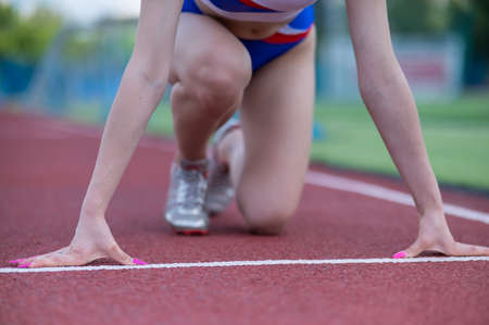 Close-up of female legs. The runner in the stadium is ready for the race.