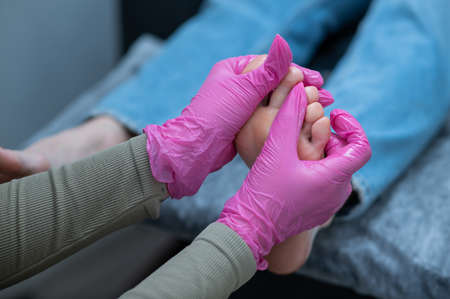 The master applies the cream and massages the feet of a female client.の写真素材