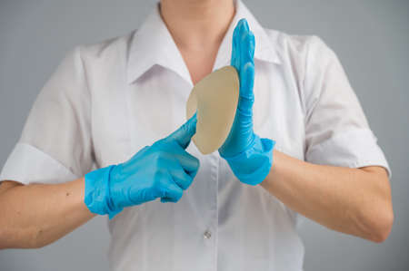 A plastic surgeon shows a breast silicone implant.の写真素材