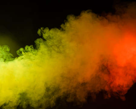 Red-yellow smoke spreads on a black background.の写真素材