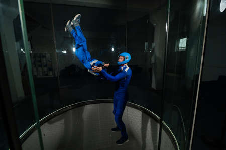 A man teaches a boy to fly in a wind tunnel. Lack of gravity.の写真素材