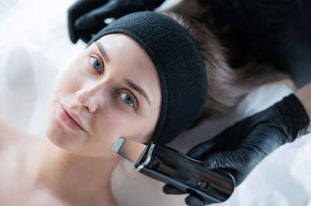Top view of a woman on an ultrasonic cleaning procedure. Hardware cosmetology.