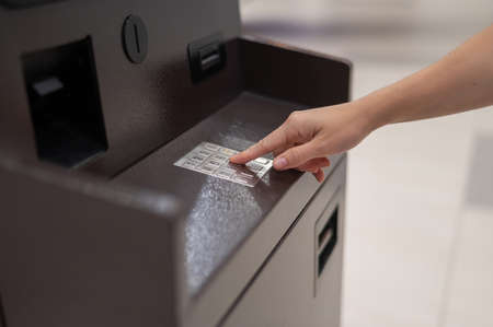Faceless woman dialing bank card pin at ATM.の写真素材