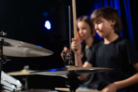 Young woman teaching boy to play drums.の写真素材