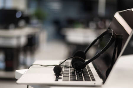 Headset on a laptop keyboard in an empty office.の写真素材