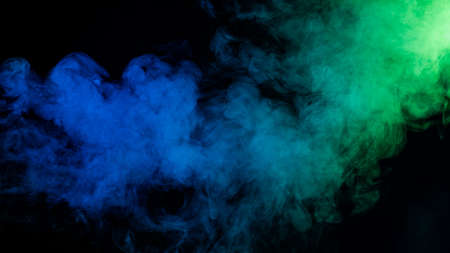 Green-blue smoke in neon light on black background.の写真素材
