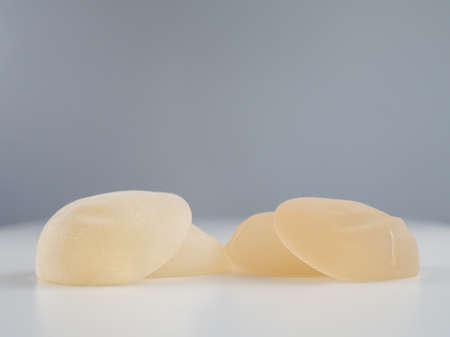 Two pairs of different breast implants on a white table.の写真素材