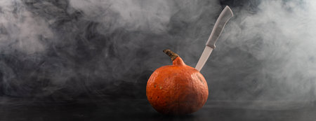A knife in a pumpkin in the smoke. Happy Halloween.の写真素材