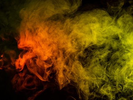 Red-yellow smoke spreads on a black background.の写真素材