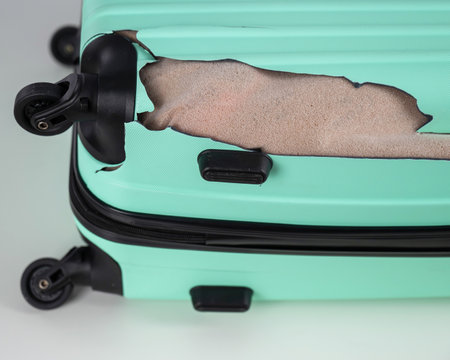 Mint damaged suitcase on a white background.の写真素材