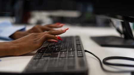 African woman is typing on the keyboard. Close-up of female hands of an office worker.