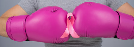 Close-up of womens boxing gloves and pink ribbon.の写真素材