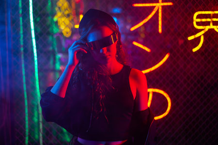 Caucasian woman in sunglasses posing in fog in neon studio.の写真素材