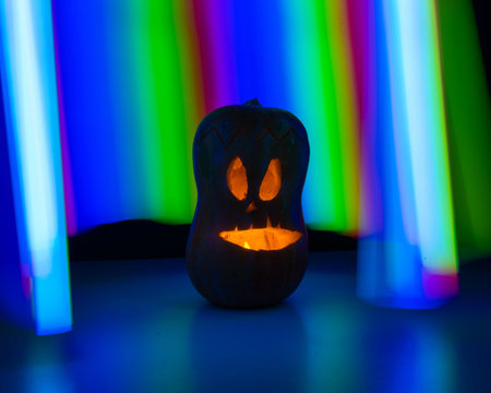 Jack-o-lantern glow in the dark against the backdrop of a rainbow. Halloween decoration.