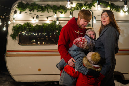 Happy caucasian family hugging outdoors. Christmas decorations. Parents and three sons travel in a...