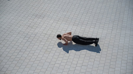 A man doing push-ups with flying outdoors.