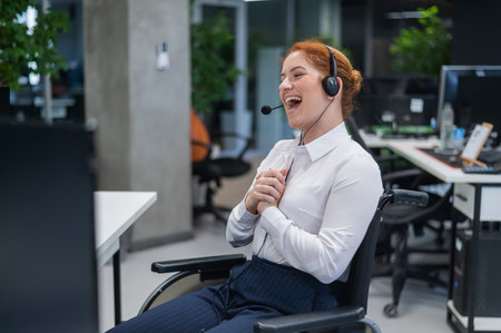 Red-haired caucasian woman in a wheelchair talking on a headset. Female call center worker smiling.