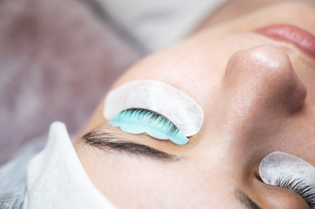 Close-up portrait of a woman in a beauty salon on eyelash lamination procedure.の写真素材