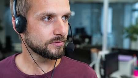 Caucasian bearded man with a headset. Male call center worker