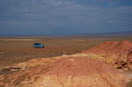 Landscape of multi-colored clay dunes. Mars on earth. Blue car.の写真素材