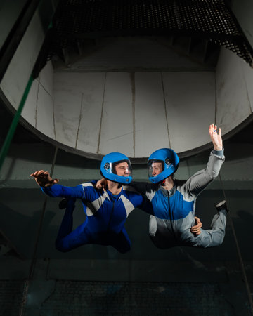 A man and a woman enjoy flying together in a wind tunnel. Free fall simulator