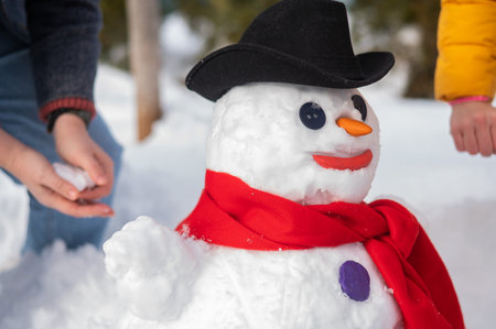 Two faceless Caucasian women are making a snowman. Winter fun.の写真素材