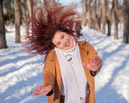 Fat caucasian woman dancing on a walk in the park in winter.の写真素材