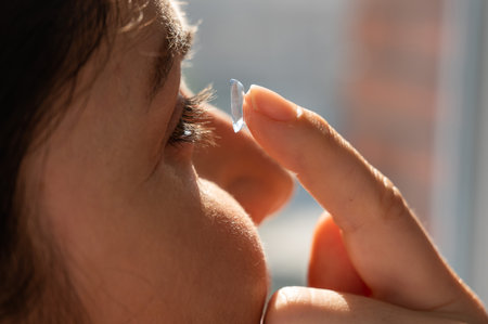 Close-up portrait caucasian woman putting on a contact lens.の写真素材