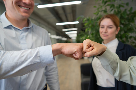 Caucasian man bumping his fists with colleagues as a sign of success.の写真素材