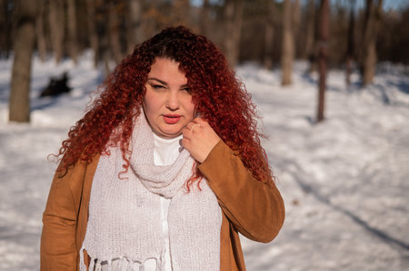 Portrait of a chubby red-haired woman on a walk in winter.の写真素材