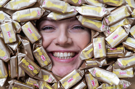 The face of a caucasian woman surrounded by Rakhat chocolates.のeditorial素材