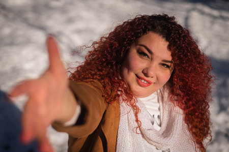 Portrait of a smiling chubby red-haired woman on a walk in winter.の写真素材