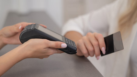 Woman paying with credit card using NFC contactless payment.