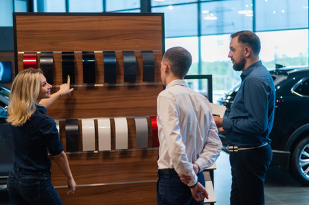The seller helps a married couple choose the color of a new car.の写真素材