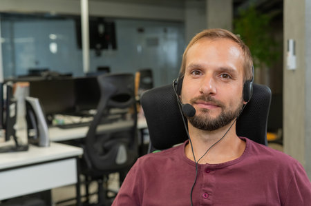 Caucasian bearded man with a headset. Male call center worker