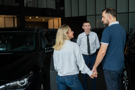 Happy caucasian couple choosing a new car in a car dealership.の写真素材