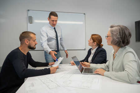 Caucasian man leading a presentation to colleagues at a white board.の写真素材